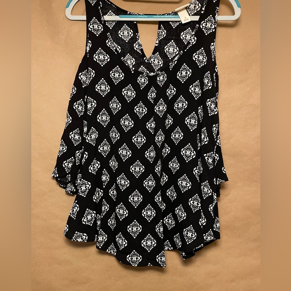Open shoulder scoop neck top. Curved bottom. Black and white pattern